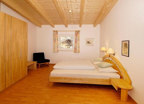 Schlafzimmer mit einem Bett mit einem Kopfteil aus Holz in der Unterkunft Residence Andrea in Algund