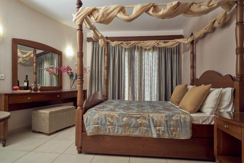 ein Schlafzimmer mit einem Himmelbett und einem Spiegel in der Unterkunft Ionion Blue Hotel Zante in Kalamaki