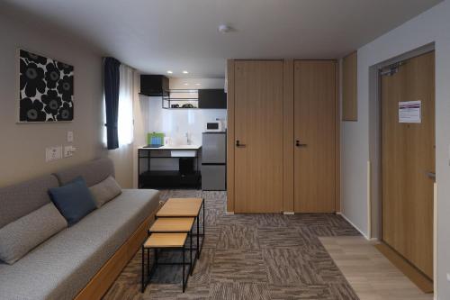 a living room with a couch and a kitchen at Koti Sopo Universal Bay 1 by Liaison in Osaka