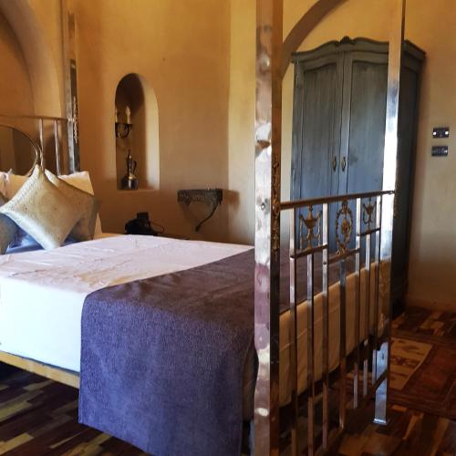 a bedroom with a bed and a wooden cabinet at Djorff Palace in Luxor