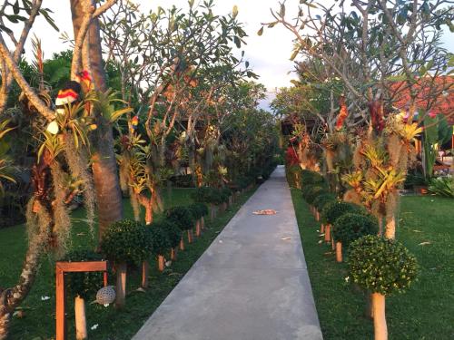 a walkway through a garden with trees and plants at Baan Thai Lanta Resort in Ko Lanta