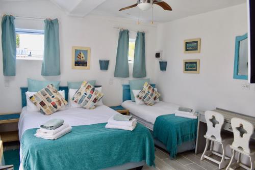 The Green Palm Cottage في بليتنبيرغ باي: سريرين في غرفة باللون الأزرق والأبيض
