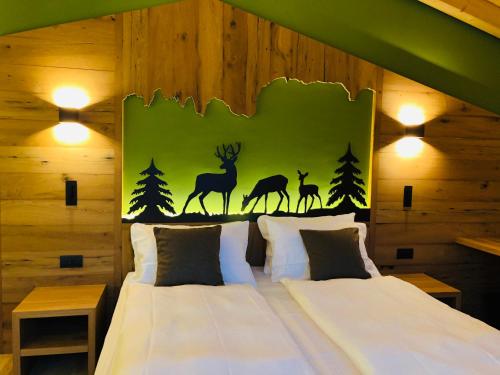 - une chambre avec un lit doté d'un mur avec des vignettes de cerf dans l'établissement Fulun Mountain Lodge, à Giustino