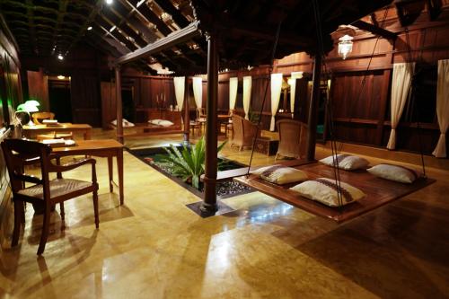 a room with a table and chairs and a dining room at Vismaya by Moksha Stays in Turavūr