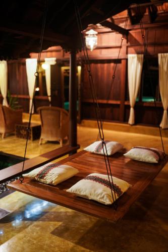 four pillows on a wooden table in a room at Vismaya by Moksha Stays in Turavūr