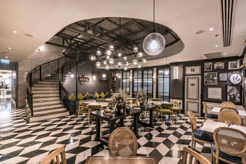 a restaurant with tables and chairs and a staircase at The Salil Hotel Sukhumvit 57 - Thonglor in Bangkok