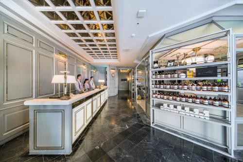 a bar in a restaurant with two people standing at a counter at The Salil Hotel Sukhumvit 57 - Thonglor in Bangkok
