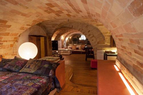 um quarto com uma cama numa parede de pedra em MarcheAmore - Bottega di Giacomino for art lovers, with private courtyard em Fermo
