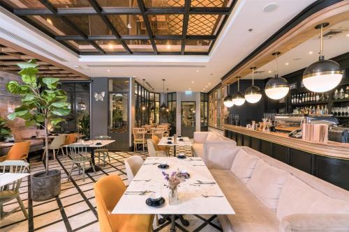 a restaurant with tables and chairs and a bar at The Salil Hotel Sukhumvit 57 - Thonglor in Bangkok
