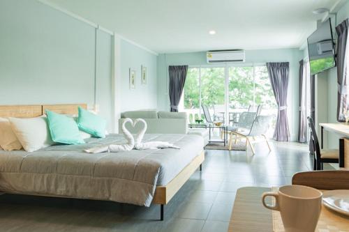 a bedroom with a bed and a living room at THE BEACH CHA AM Suites in Cha Am