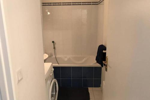 łazienka z wanną, toaletą i umywalką w obiekcie Appartement Stella-Plage w mieście Cucq