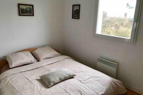 a bedroom with a bed with two pillows and a window at Appartement Stella-Plage in Cucq