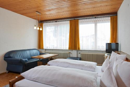 ザンクト・ガレンキルヒにあるHaus Wasserfallのベッド2台、テーブル、椅子が備わる客室です。