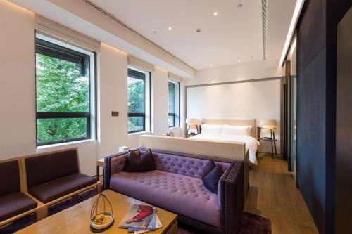 una camera con un letto e un divano viola di Diaoyutai Boutique Hotel Chengdu a Chengdu