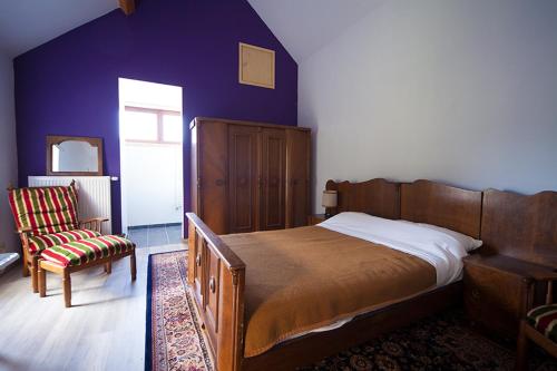 - une chambre avec un grand lit et une chaise dans l'établissement B&B t'Keygoed, à Gand