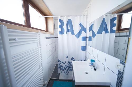 a bathroom with a shower curtain and a sink at B&B t'Keygoed in Ghent