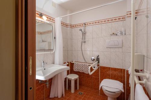 a bathroom with a sink and a shower and a toilet at Hotel Gabbiano in Porto San Giorgio