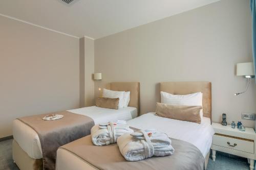 two beds in a hotel room with towels on them at New Era Hotel Old Town Bucharest- parking with fee nearby - NOT at the hotel ! in Bucharest