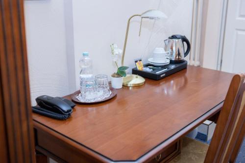 a wooden table with a telephone and a bottle on it at Hotel Baden in Bonn