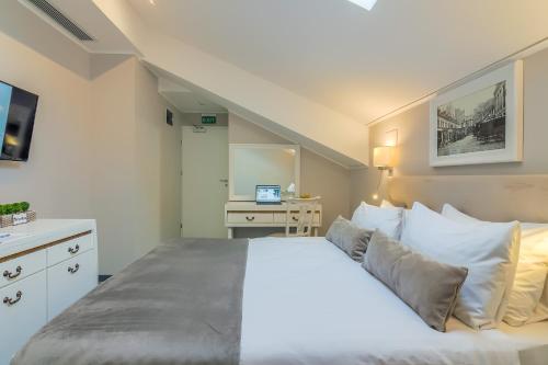 a bedroom with a large bed and a desk at New Era Hotel Old Town Bucharest- parking with fee nearby - NOT at the hotel ! in Bucharest
