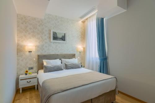 a bedroom with a large bed with blue curtains at New Era Hotel Old Town Bucharest- parking with fee nearby - NOT at the hotel ! in Bucharest