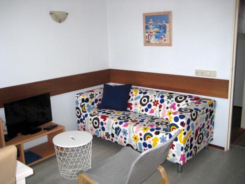 a living room with a couch and a tv at Vakantieappartementen Stuifkenszand in Hoek van Holland