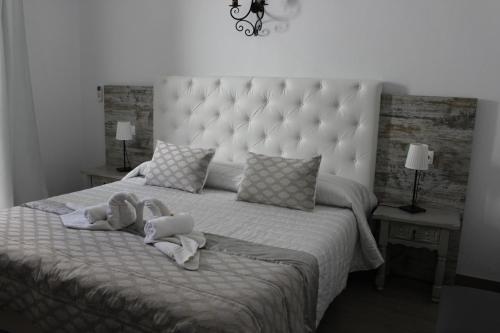 una camera da letto con un grande letto con asciugamani di Boutique Hostal Mistral a Cala d´Or