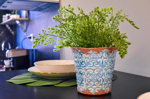a blue and white vase with a plant on a table at F.T.P Luxury Rooms in Patra