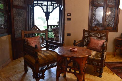 a living room with chairs and a table and a window at Djorff Palace in Luxor