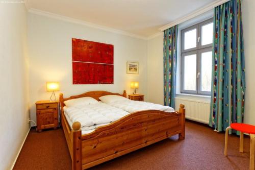 sypialnia z drewnianym łóżkiem i dużym oknem w obiekcie Haus Seeadler Wohnung Habicht w Zinnowitz