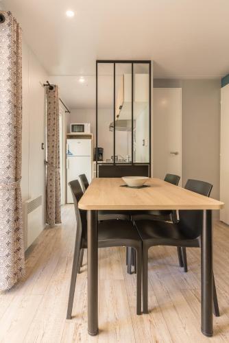 une salle à manger avec une table et des chaises noires dans l'établissement Camping Le Méditerranée Argelès - Domaine piétonnier, à Argelès-sur-Mer