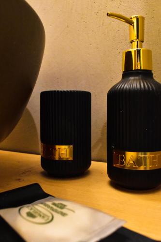 a close up of a black soap bottle on a table at F.T.P Luxury Rooms in Patra