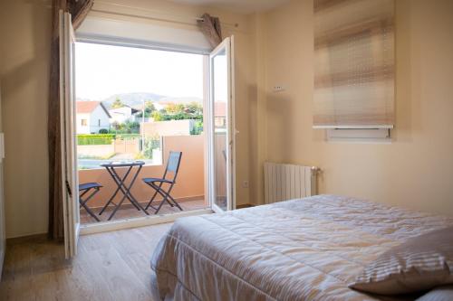 a bedroom with a bed and a balcony with a table and chairs at Apartamentos Costa Xuño in A Coruña