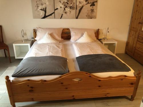 ein Schlafzimmer mit einem Holzbett mit zwei Kissen in der Unterkunft Haus am Bühl in Schönau im Schwarzwald
