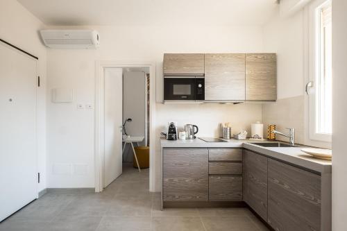 uma cozinha com paredes brancas e armários de madeira em Galleria del Reno by Wonderful Italy em Bolonha