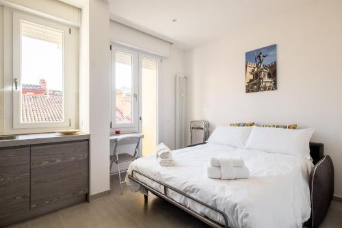 - une chambre blanche avec un lit, un bureau et une fenêtre dans l'établissement Galleria del Reno by Wonderful Italy, à Bologne