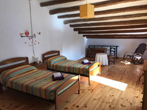 a room with two beds and a wooden floor at Masia Rural Canalisos in Adzaneta