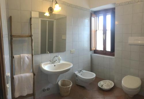 a white bathroom with a sink and a toilet at Casale sostenibile per famiglie e gruppi Cibottola PG in Piegaro