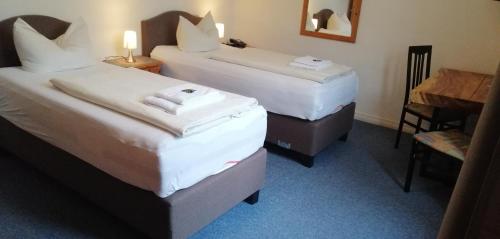 a hotel room with two beds and a table at Hotel Holsteinische Schweiz am Dieksee in Malente