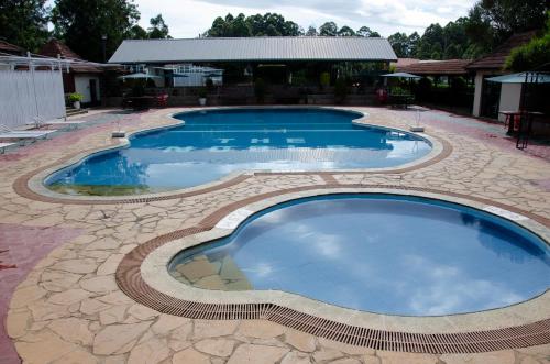 a large swimming pool with a stone pathway around it at The Noble Hotel & Conference Centre in Eldoret