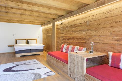 a wooden room with a bed and a table at Golf- und Sporthotel Moarhof in Walchsee