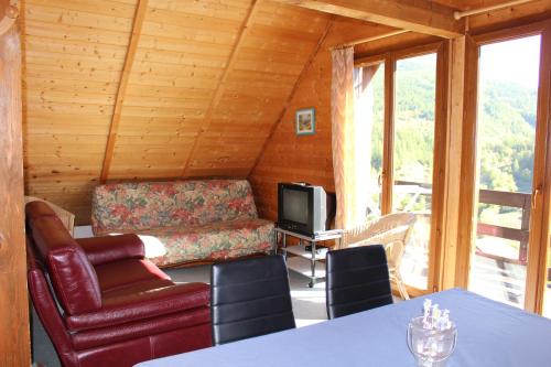 a living room with a couch and a television at Grand Chalet 15 personnes. Vue exceptionnelle . Plein sud in Allos