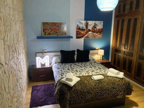 a bedroom with a large bed with towels on it at Vivienda turistica Pop Bowie House in Úbeda