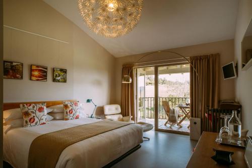 a bedroom with a large bed and a chandelier at el gran sueño Boutique Hotel & Apartamentos - Adults Only in Pintueles