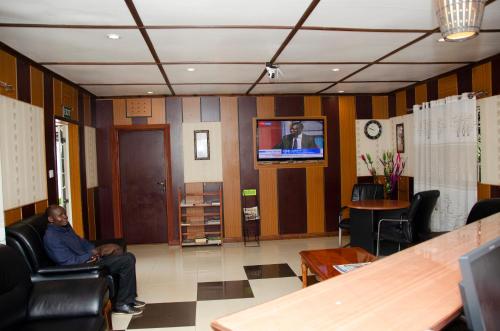 a man sitting in a chair in a waiting room at The Noble Hotel & Conference Centre in Eldoret