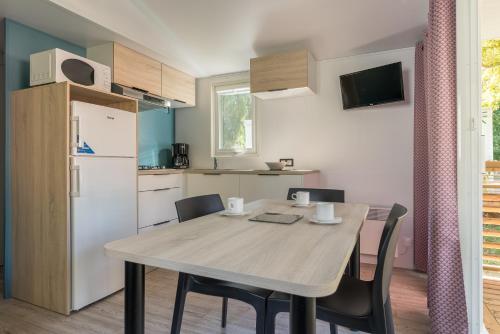 a kitchen and dining room with a table and chairs at Camping Le Méditerranée Argelès - Domaine piétonnier in Argelès-sur-Mer