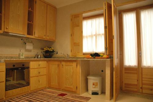 eine Küche mit Holzschränken und einer Arbeitsplatte in der Unterkunft Casa Avó Alice in Seia