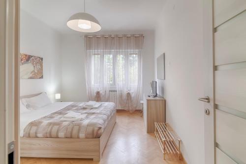 - une chambre blanche avec un lit et une fenêtre dans l'établissement La fine del mondo, à Trieste