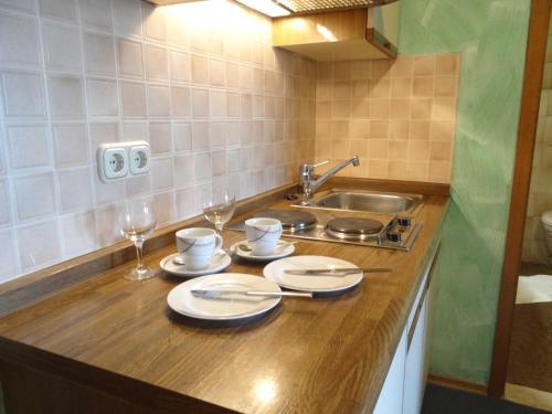 a kitchen counter with plates and glasses and a sink at Beim Haxenwirt in Immenstadt im Allgäu