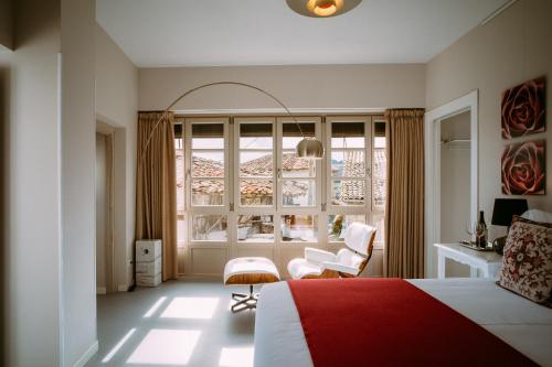 Schlafzimmer mit einem roten und weißen Bett und einem Fenster in der Unterkunft el gran sueño Boutique Hotel & Apartamentos - Adults Only in Pintueles